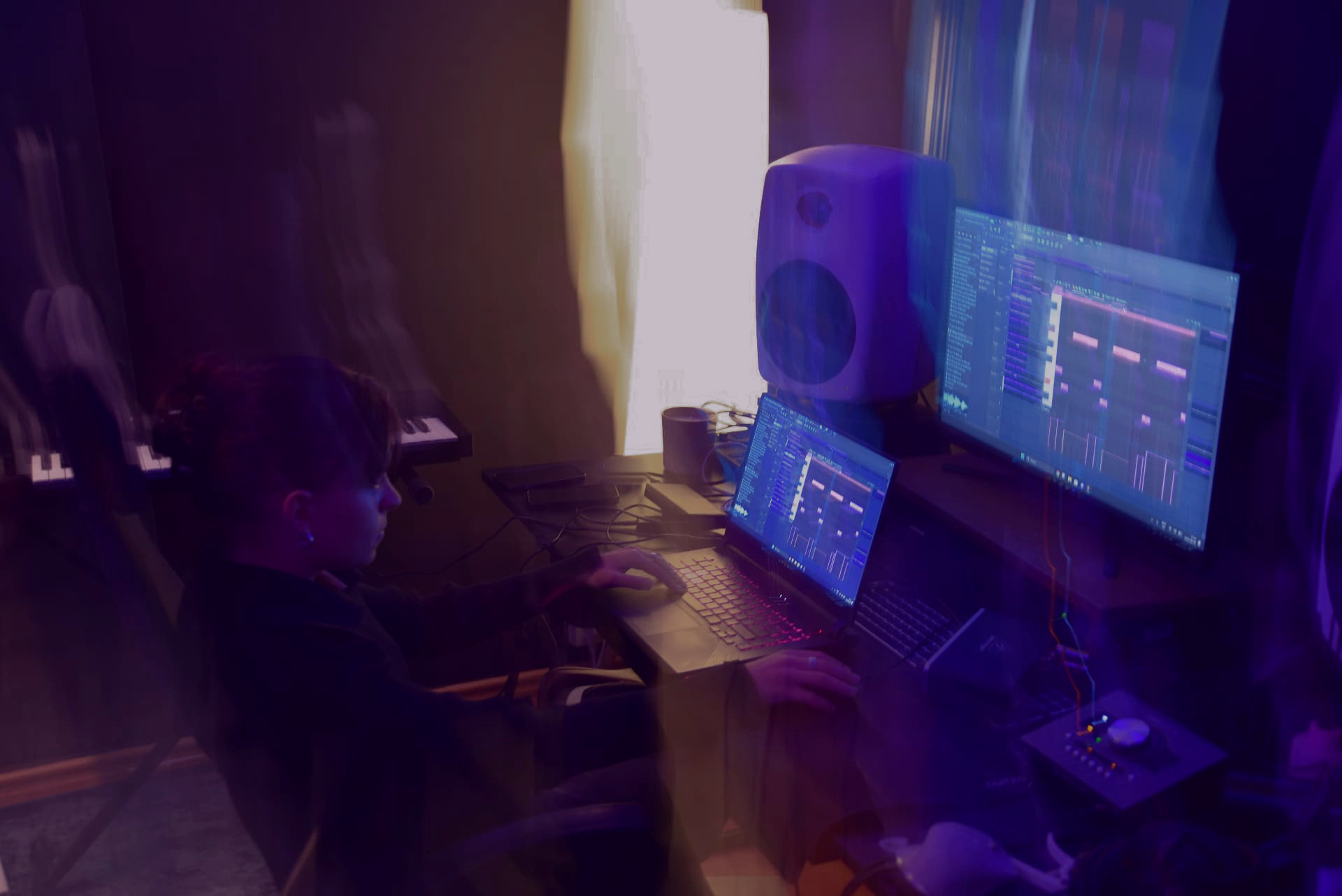 Working on a production session at the studio desk, graded in cold chrome blue